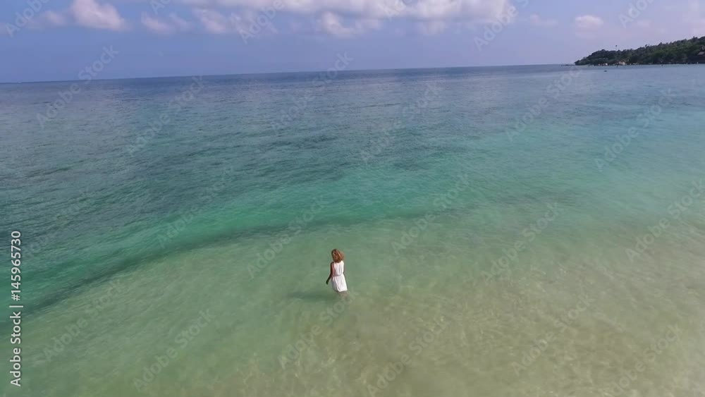 Aerial View: Young Woman in White Dress in Sea on Island Aerial View: Young Woman in White Dress in Sea on Island