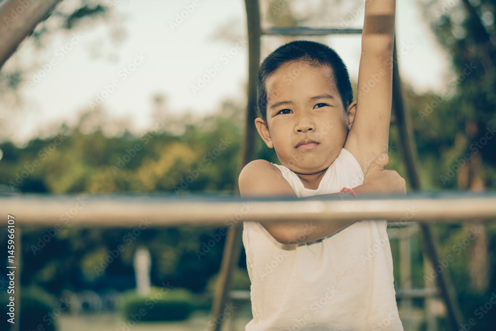 Fototapeta premium Boy with exercise machines in the park