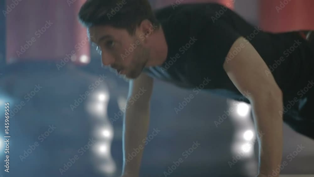 Ragazzo con maglietta nera si sta allenando in palestra con i piegamenti a terra