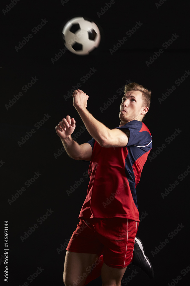 Professional Soccer Player Jumping To Head Ball In Studio Stock Photo |  Adobe Stock