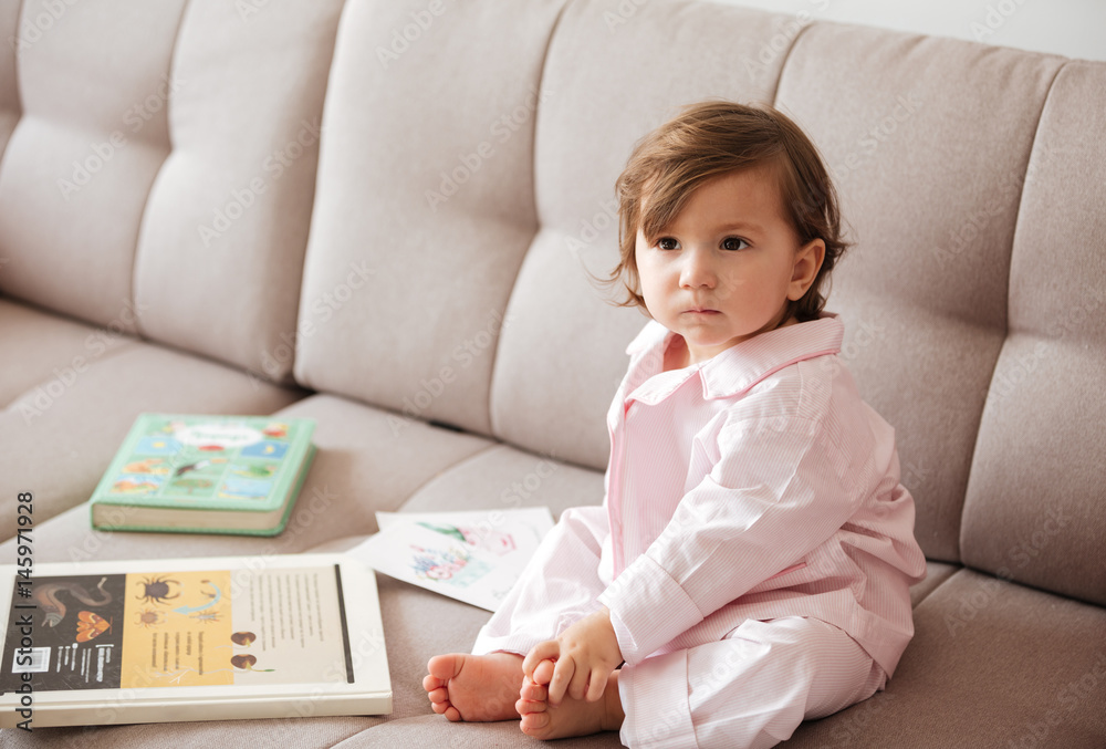 Pensive child sitting on sofa