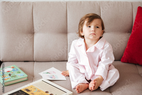 Little child sitting on sofa photo