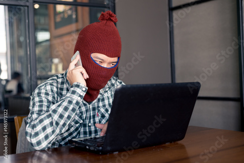 electronic crime concept. hacker is calling while using computer. photo