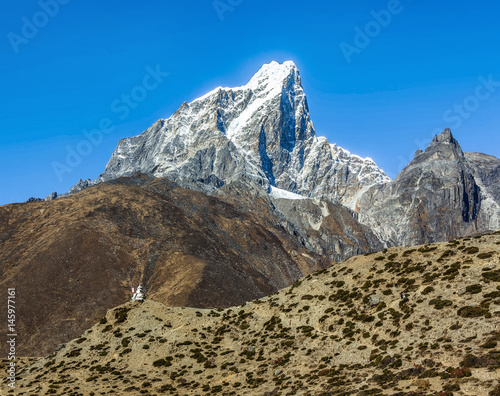 View from the village of Dingboche at ancient Buddhist stupa on the background of peak Tabuche - Everest region, Nepal, Himalayas photo