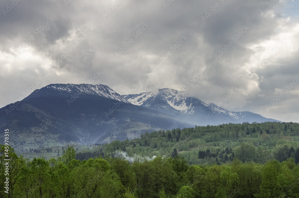 Panorama of Carpathians mountains with stormy clouds sky and snow on the tops,Transylvanian,Romania,Europe