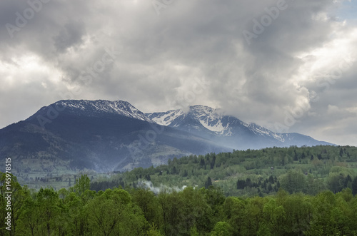 Panorama of Carpathians mountains with stormy clouds sky and snow on the tops Transylvanian Romania Europe