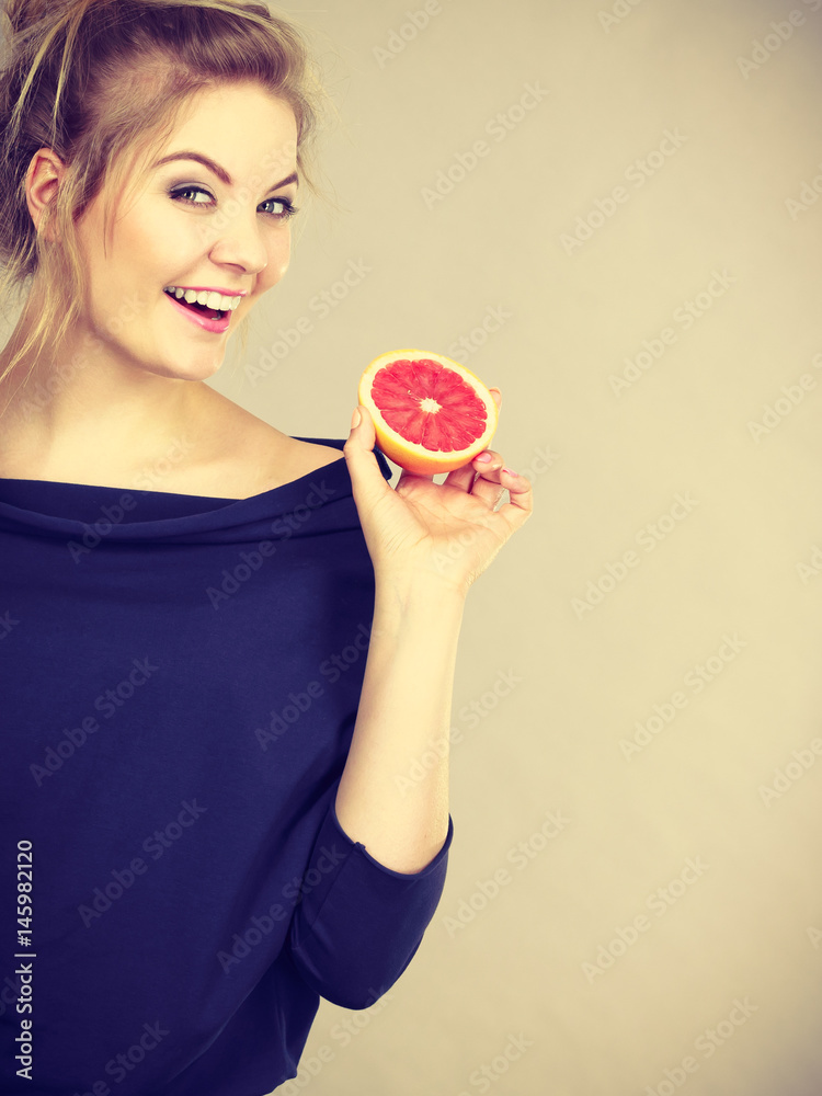 Happy smiling woman holding red grapefruit Happy smiling woman holding red grapefruit