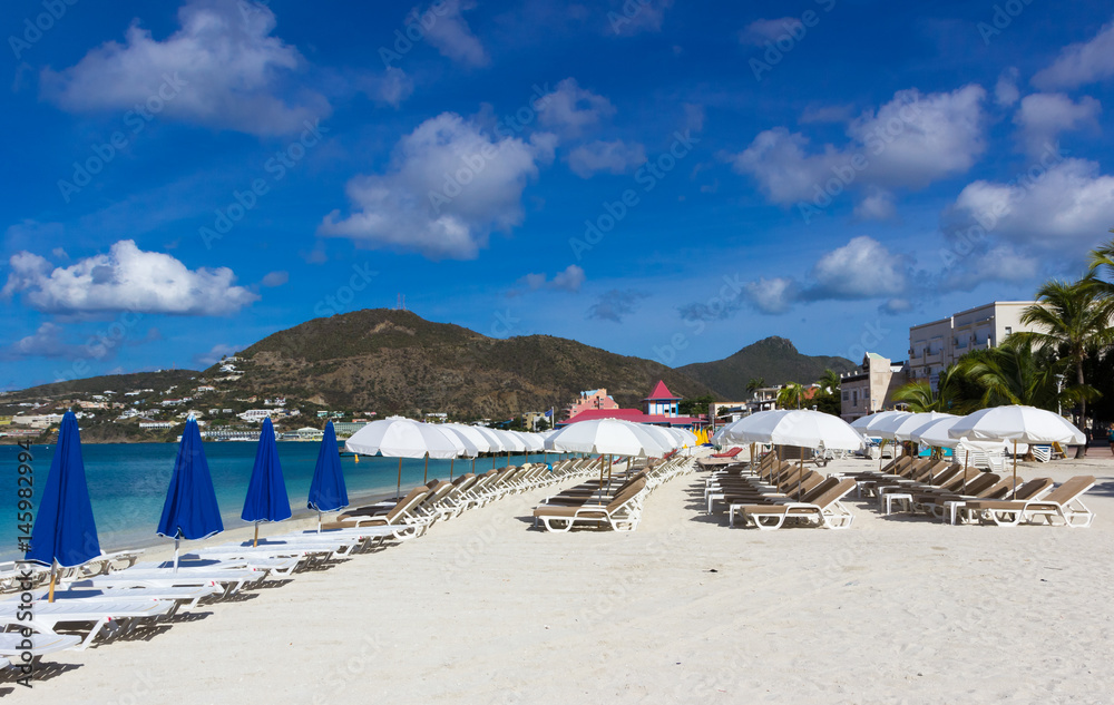  beach chairs and  white umbrellas on caribbean island