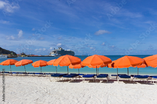  beach chairs and  white umbrellas on caribbean island St. Marten