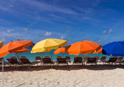 Colorful beach chairs and umbrellas on white sand caribbean coast © elvirkin