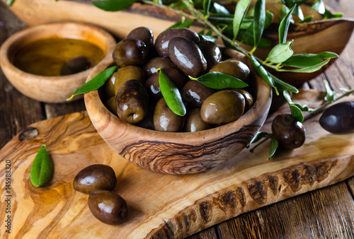Olives and olive oil in olive wooden bowls