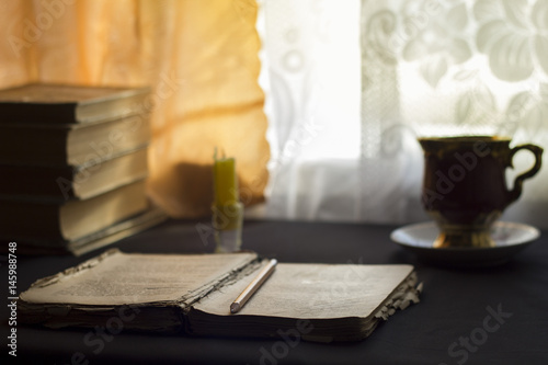 Open book on a table with a candle  day light