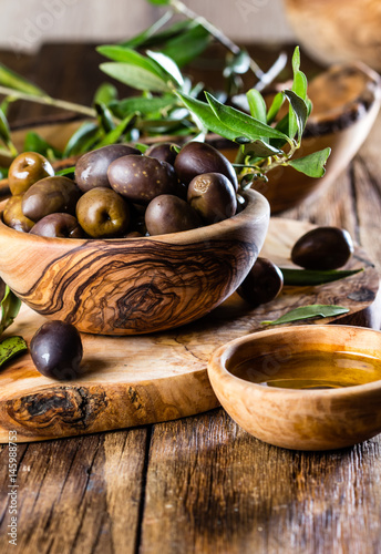 Olives and olive oil in olive wooden bowls