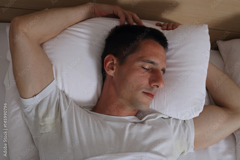 Young handsome man sleeping comfortably in bed. Young handsome man sleeping comfortably in bed.