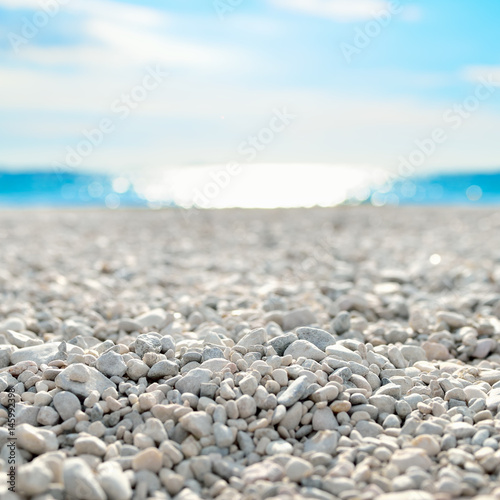 On the Beach by the Sea - beautiful white pebble beach at the mediterranean coast on a beautiful day