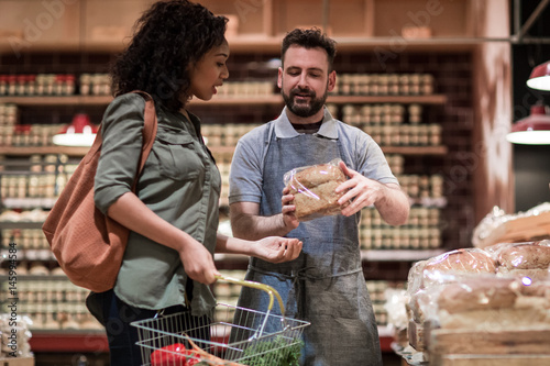 Baker helping customer in grocery store photo