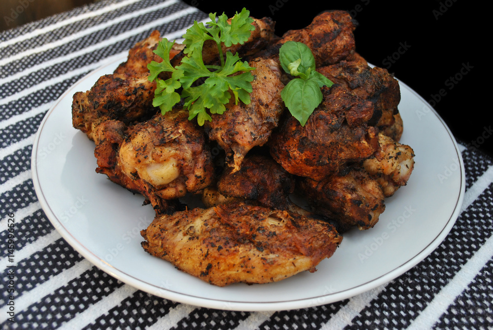 Plate of Grilled Chicken Wing Pieces Garnished with Parsley and Basil Plate of Grilled Chicken Wing Pieces Garnished with Parsley and Basil