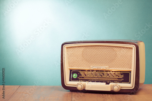 Old retro radio with green eye light on table front gradient background