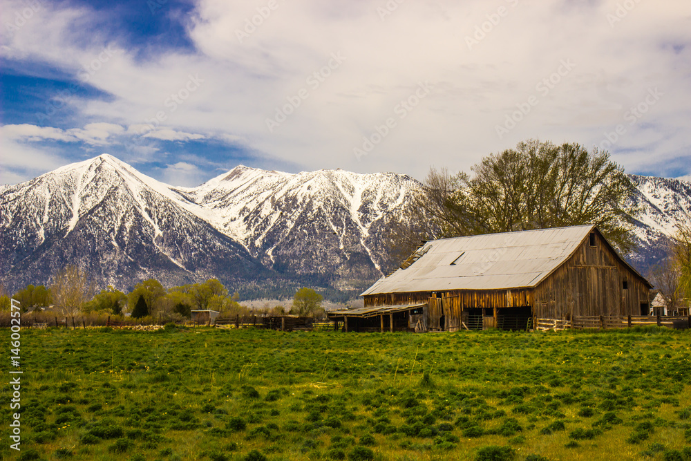 Old Rustic Barn At Base of Snow Covered Mountains