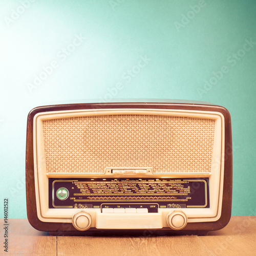 Retro radio receiver on table front mint green background
