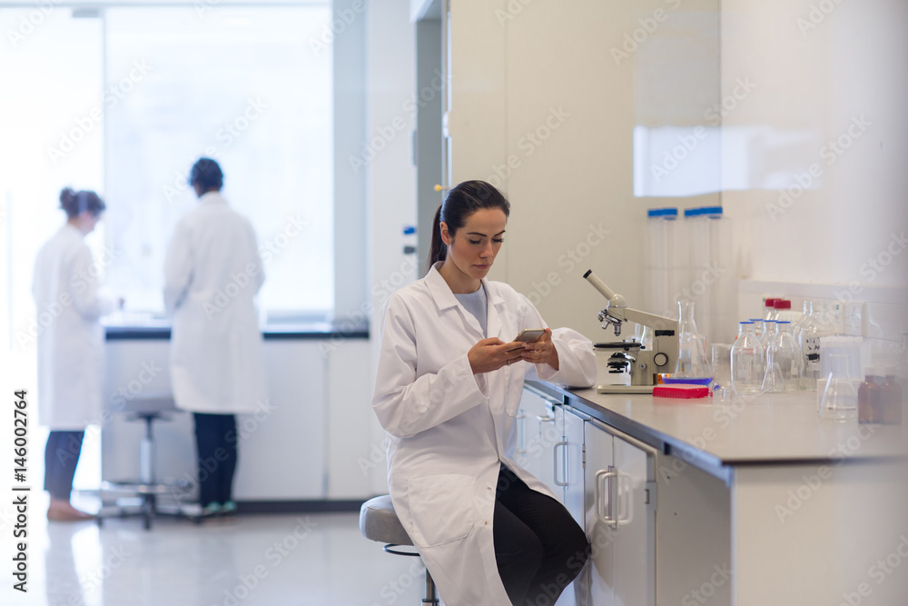 Female scientist using smartphone in laboratory