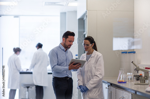 Female scientist discussing data with pharmaceutical sales rep