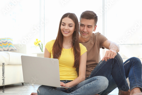 Young couple using laptop t...
