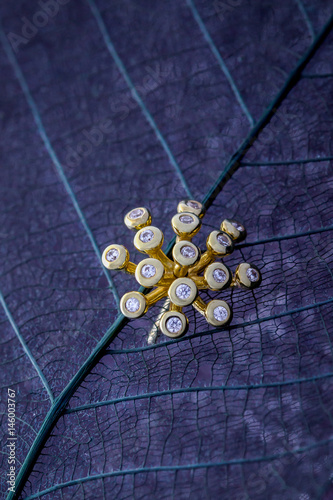 Gold pendant dandelions on a dark background