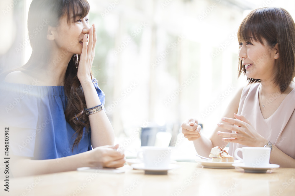 Women are eating cakes at a cafe Women are eating cakes at a cafe