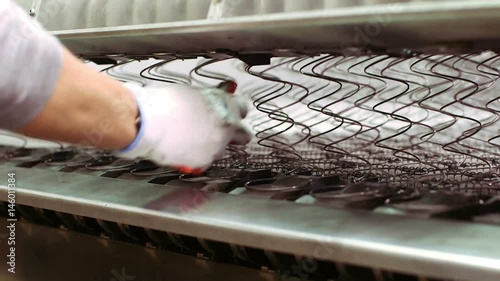Worker manufacturing mattress in factory