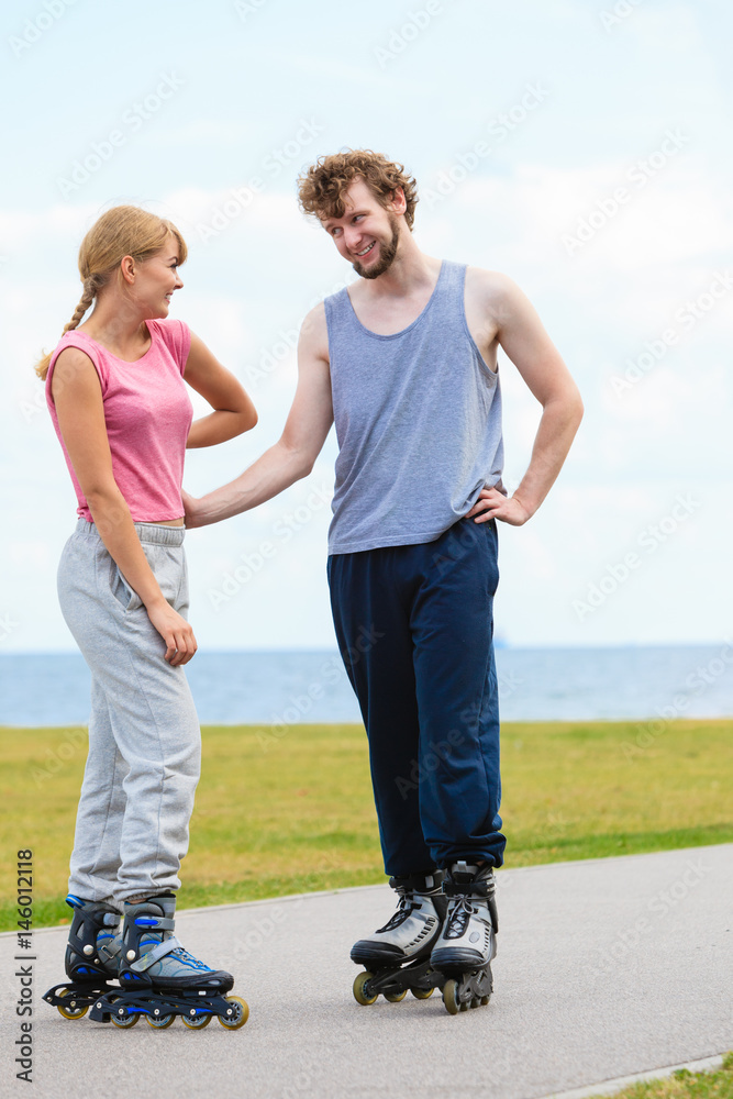 Fototapeta premium Couple wearing rollerskates looking at each other