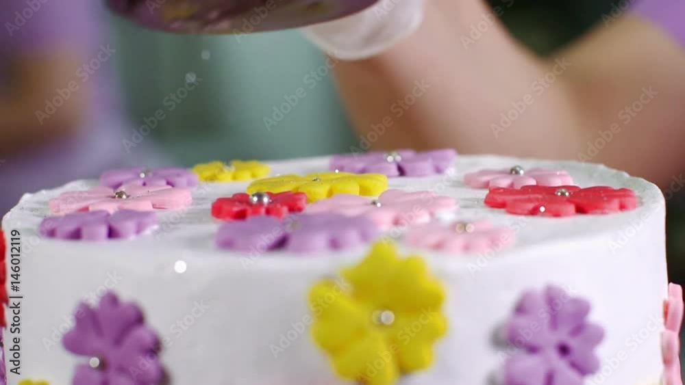 Worker decorating pastries at a commercial bakery