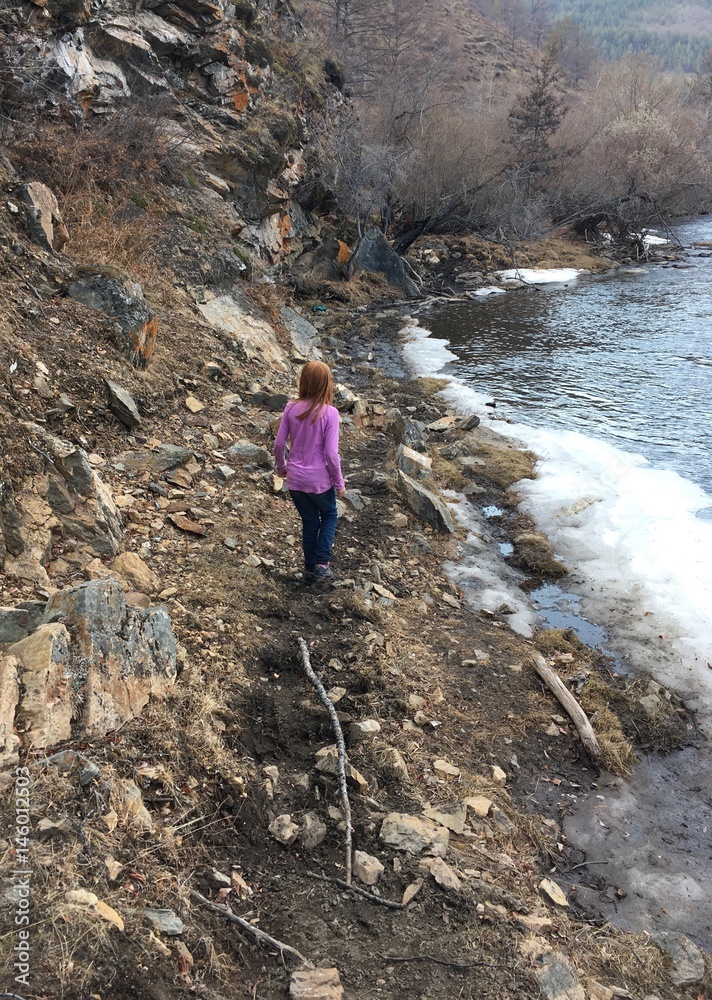 девочка идущая по берегу горной реки 