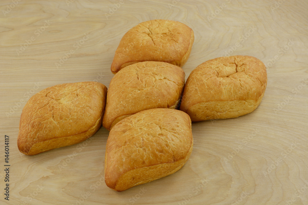 Bolillo Mexican white bread loaves on wooden table