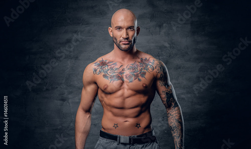 Fotografia, Obraz Shaved head, muscular male with tattoos on his torso over grey vignette background