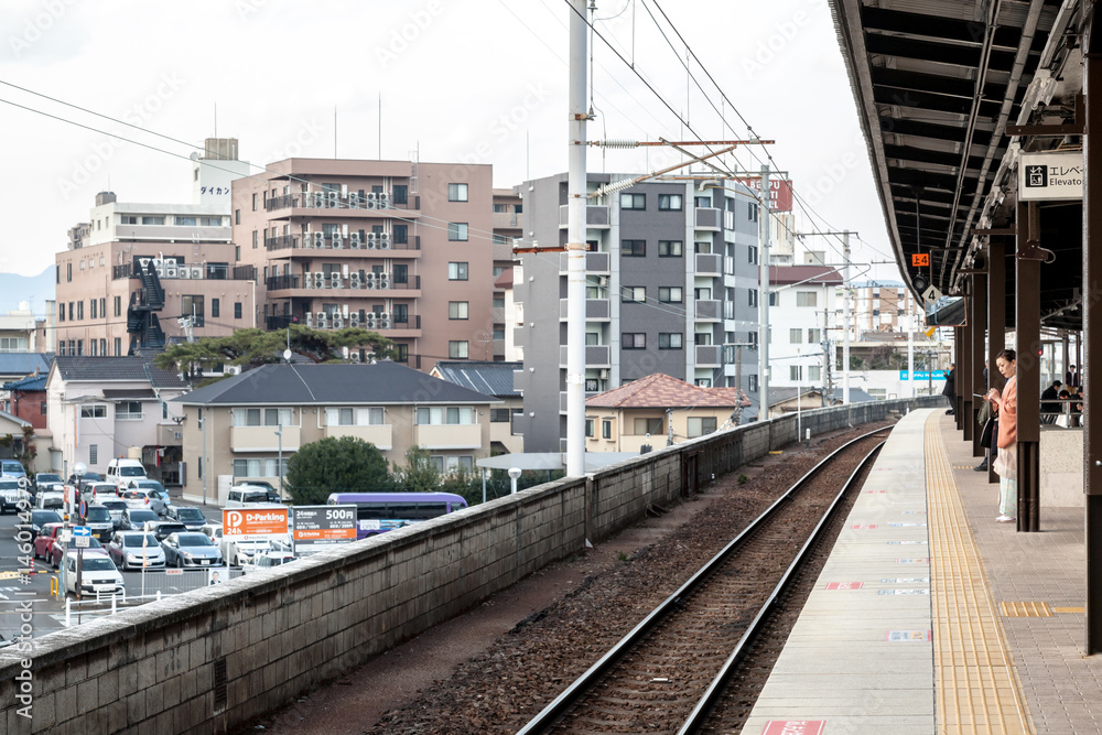 BEPPU, JAPAN - MARCH 14, 2017 : Japanese woman is waiting a train on platform at Beppu railway station.