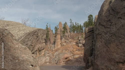 FPV, CLOSE UP: Driving on scenic steep curvy mountain pass road on Needles Highway, South Dakota. Stunning scenery of eroded granite pillars, spires and rock formations in Black Hills National Forest