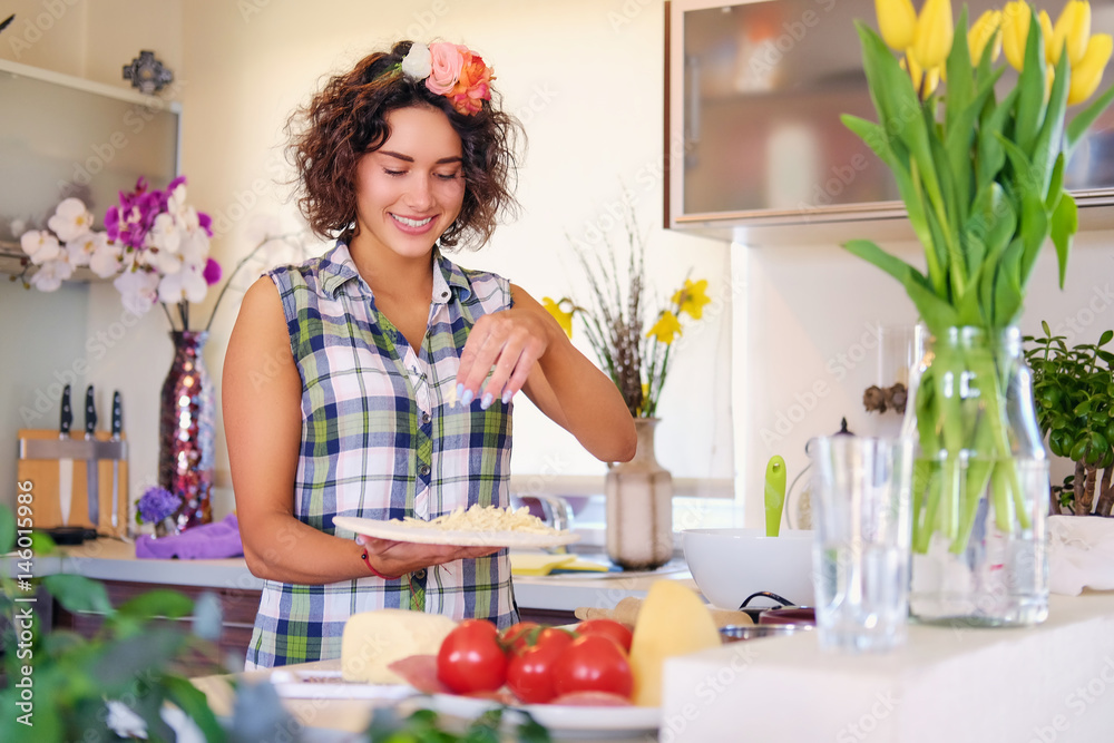 Brunette female with curly hair makes salad with tomatoes and potato in a home kitchen. Brunette female with curly hair makes salad with tomatoes and potato in a home kitchen.