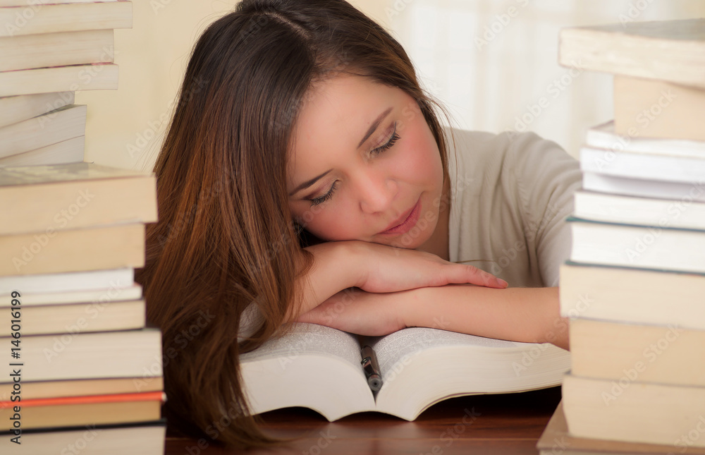 tired student completely sleep over the books in the library tired student completely sleep over the books in the library