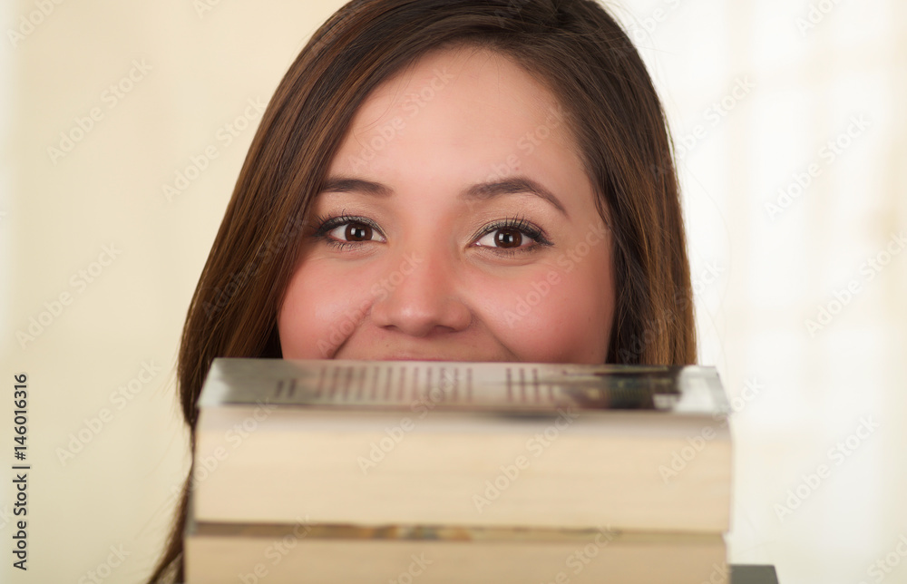 Young Pretty Woman Hiding Behind Open Book with smilingeyes Young Pretty Woman Hiding Behind Open Book with smilingeyes