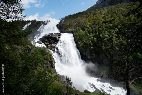 Waterfall in mountains of Norway in rainy weather.