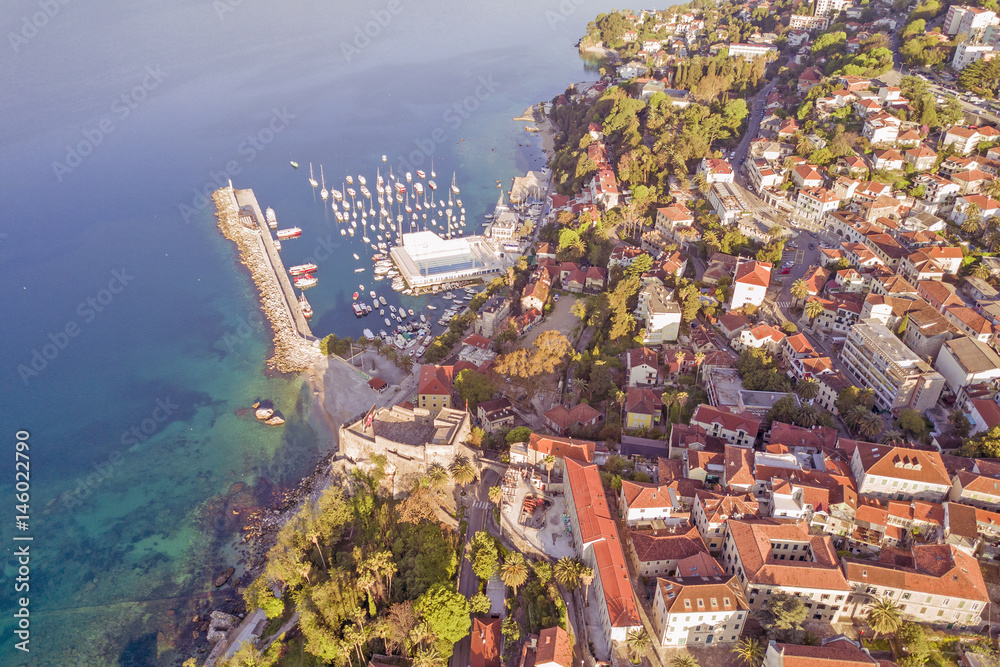 Fototapeta premium Top view of the resort town with red roofs and marina