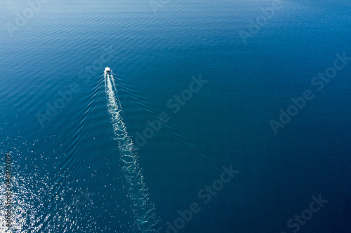 Top view of a white boat sailing to the blue sea © watman