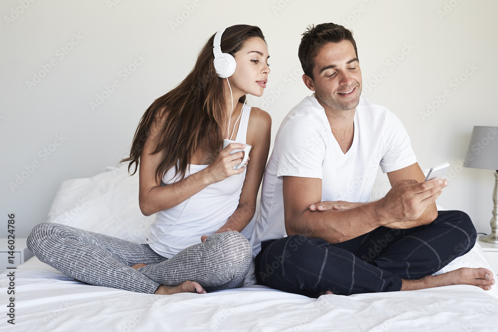 Dude texting on bed white girlfriend peers over shoulder Dude texting on bed white girlfriend peers over shoulder