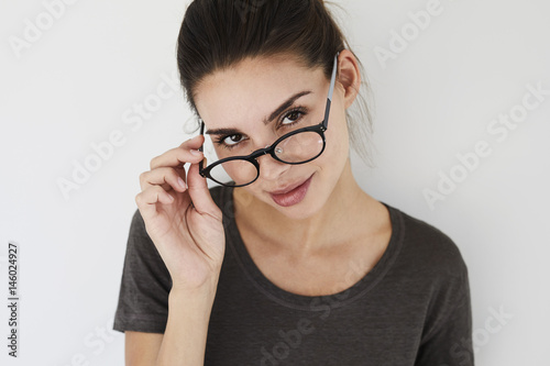 Beautiful woman looking over spectacles, portrait