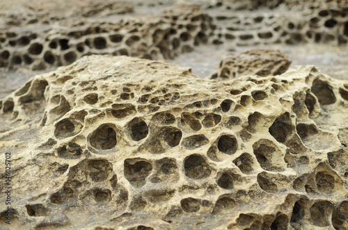 Foto Closeup rock erosion holes sea wall.