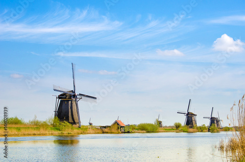 Painting a bright beautiful landscape with boats and windmills in Kinderdijk, Netherlands, Europe.