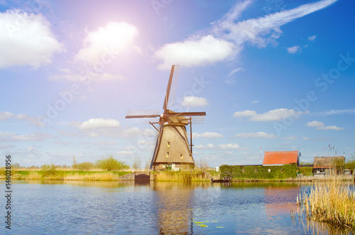 Painting beautiful picture of windmills in Kinderdijk, Netherlands, Europe against the backdrop of a cloudy sky at sunlight