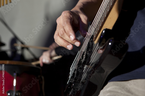 Bass guitar in hands of musician