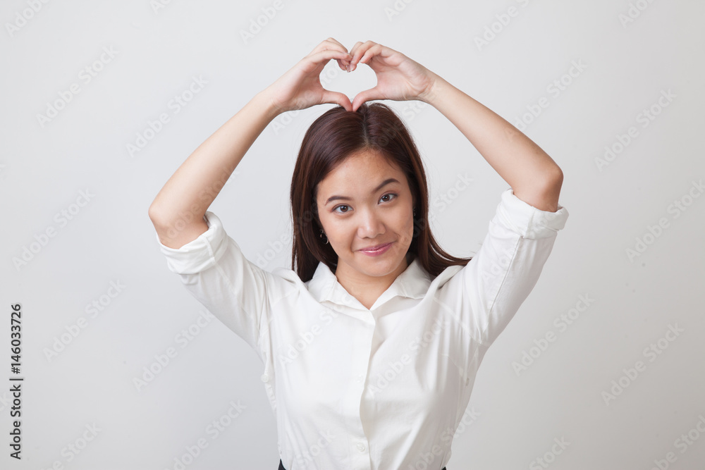 Young Asian woman gesturing heart hand sign. Young Asian woman gesturing heart hand sign.